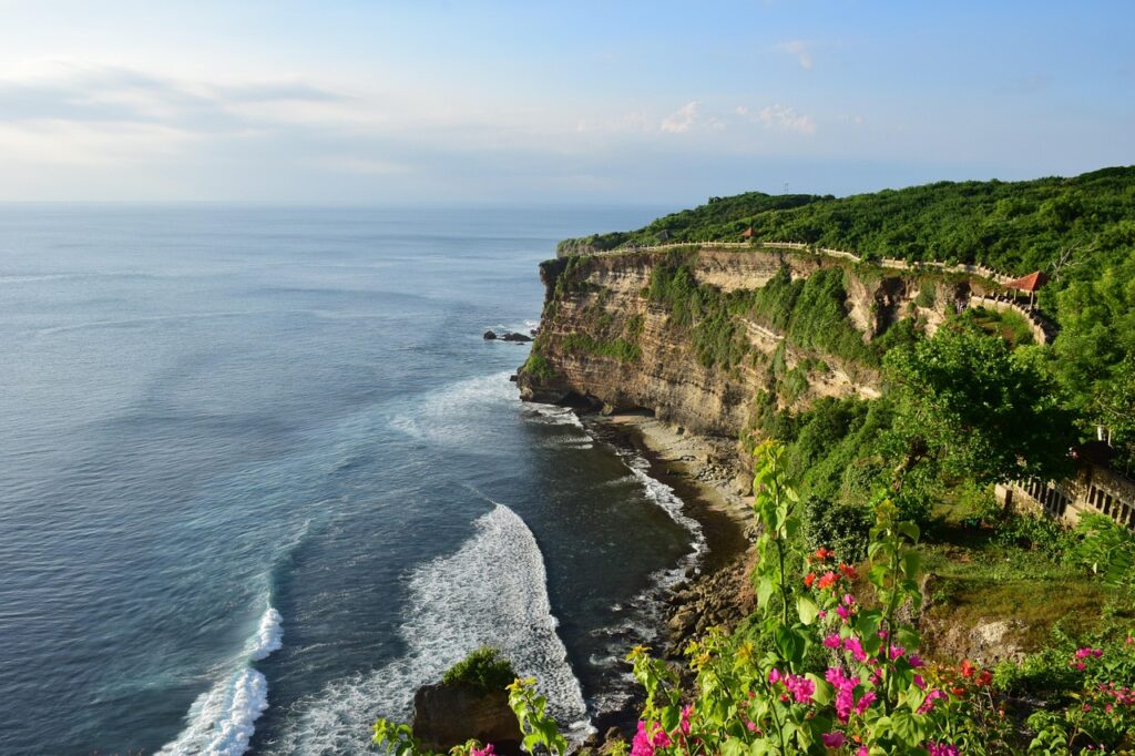 Uluwatu Temple on a cliff above the sea in Bali at sunset