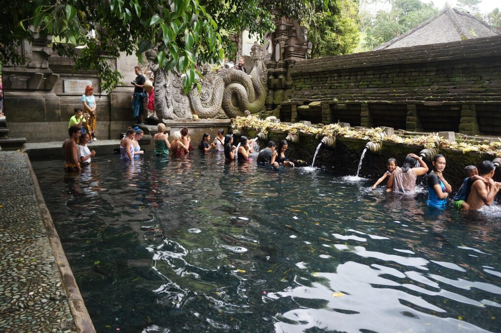 Worshippers at the holy spring pools of Tirta Empul Temple in Bali